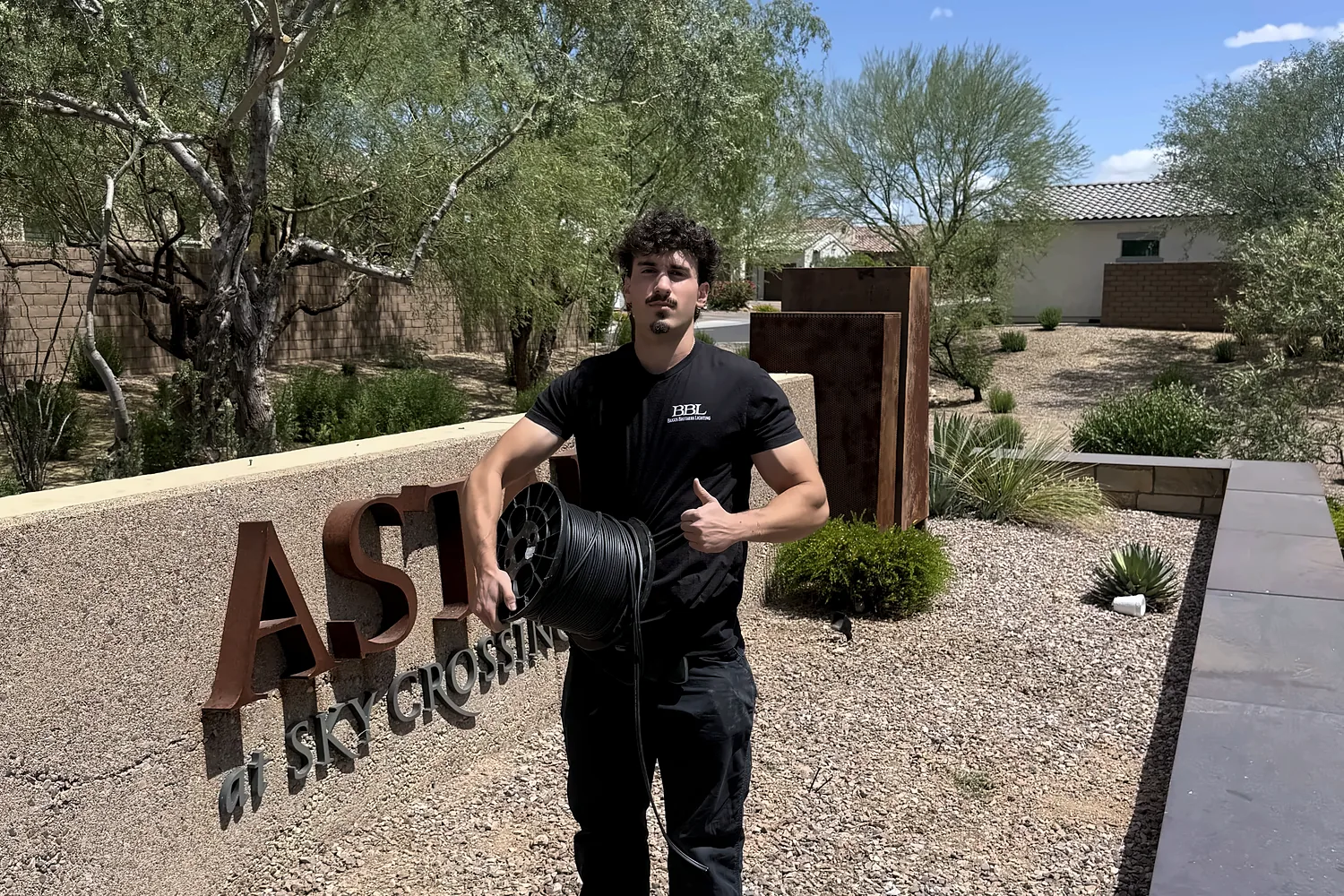 Caden Briggs installing lighting at the Aster at Sky Crossing community entry sign