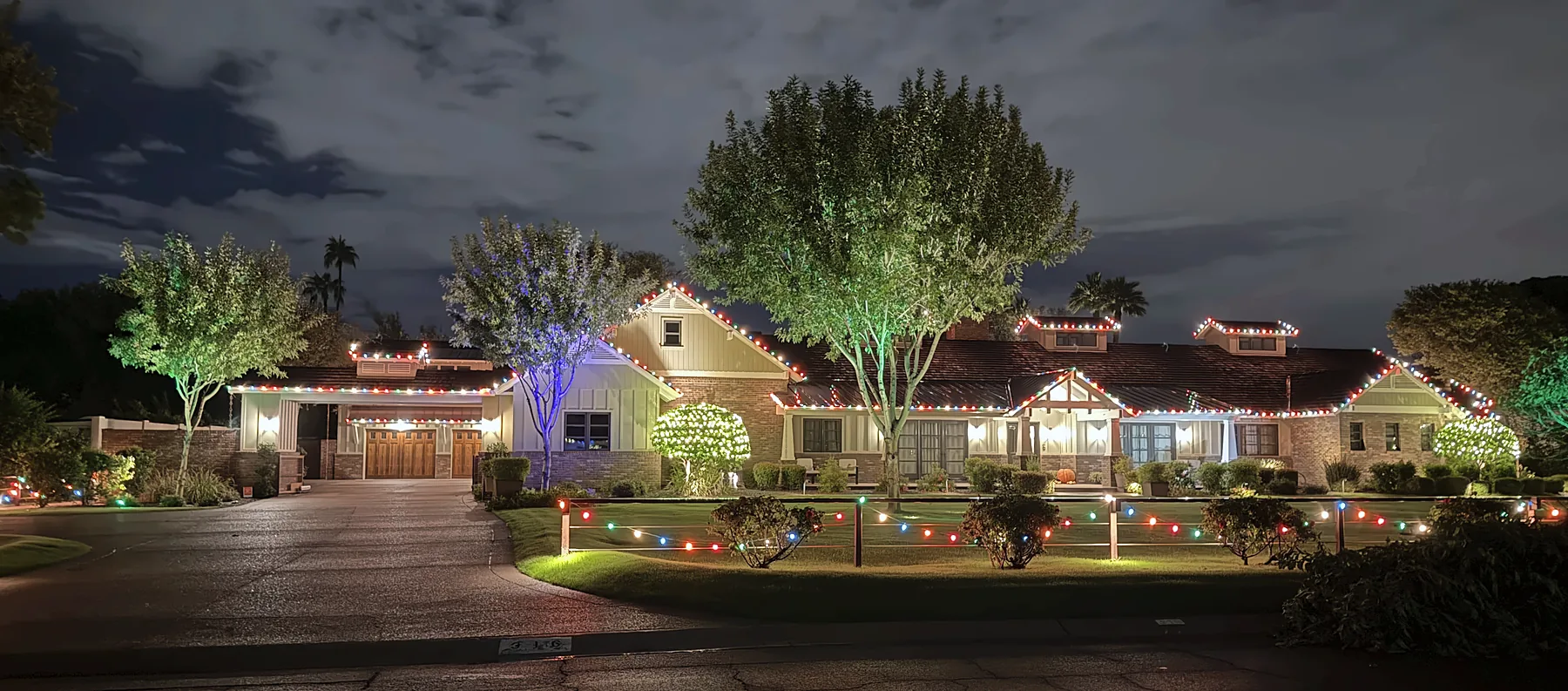 Multicolor C9 roofline, uplit trees and walkway lights on a ranch-style home