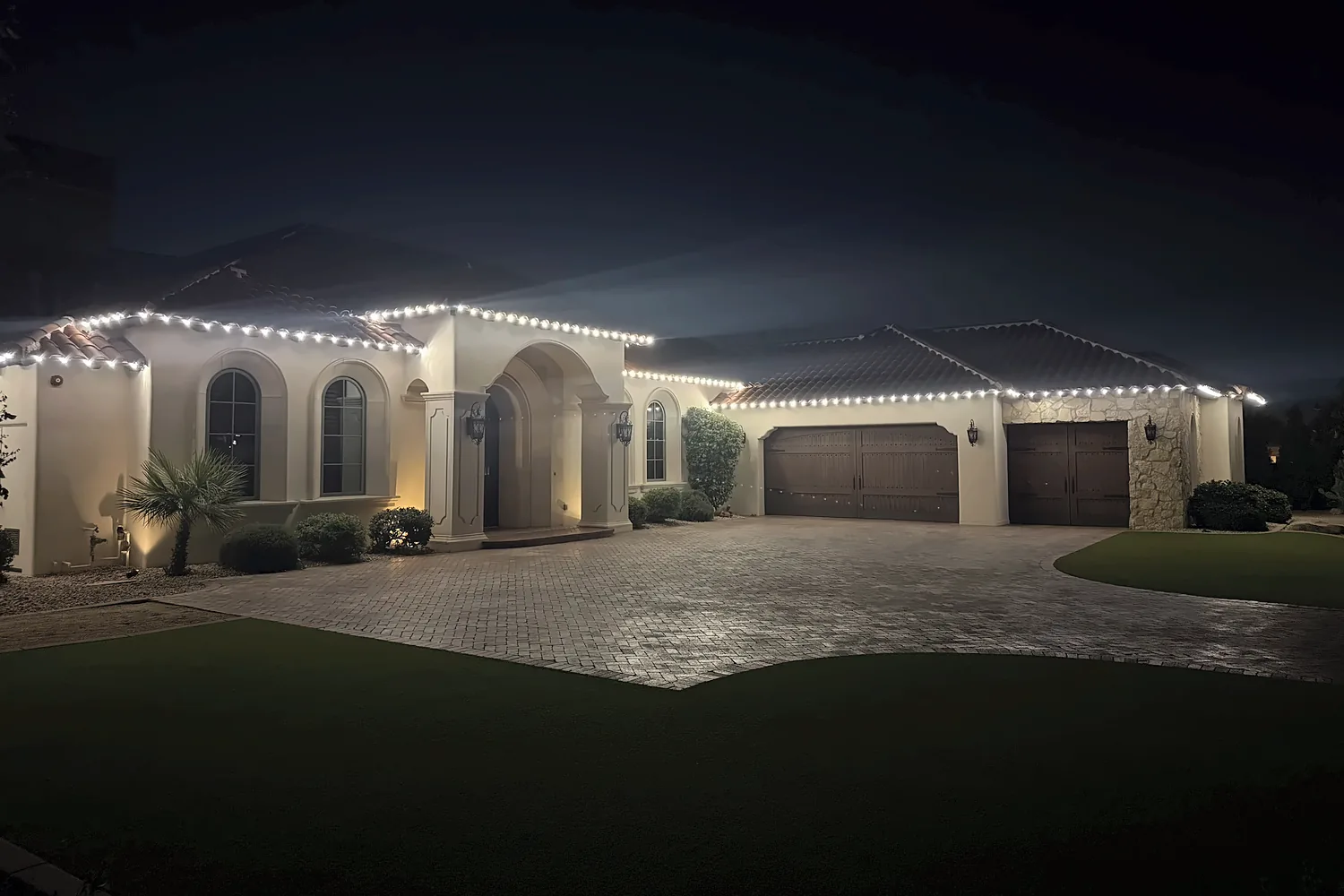 White C9 bulbs along the full roofline of a Tuscan-style estate