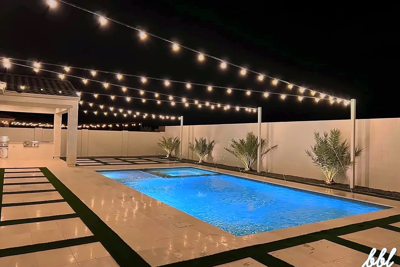 Bistro string lights over a backyard pool deck