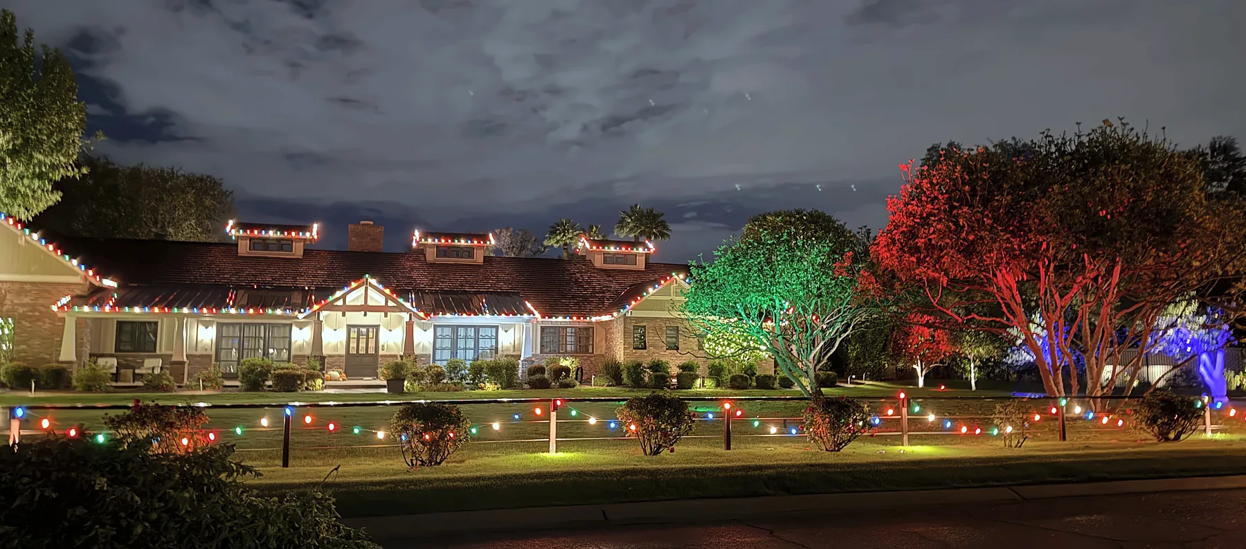 Multicolor roofline, walkway lights and red, green and blue uplit trees
